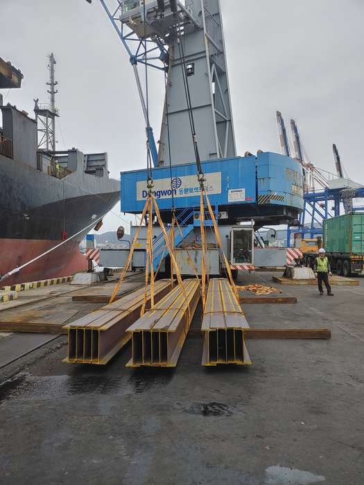 Beams lifted by quay crane alongside the vessel